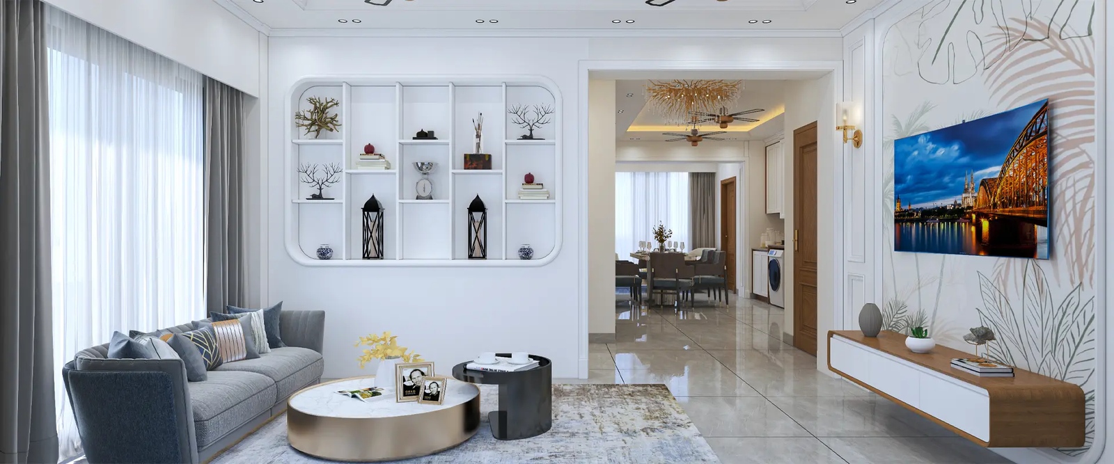 A beautifully designed modern living room that seamlessly integrates with an open dining area, perfect for stylish home interiors. The living room features a sleek grey sofa adorned with decorative pillows, facing large windows draped with sheer white curtains and grey drapes, allowing natural light to flood the space. A chic round coffee table with a marble top and a smaller black side table rest on a patterned rug, adding texture and interest. Built-in shelves on the opposite wall display an array of decorative items, including lanterns, books, and sculptures, adding personality and warmth to the room. A flat-screen TV is mounted on the adjacent wall above a floating wooden console table with white drawers, elegantly decorated with vases and books. The dining area, illuminated by a stylish chandelier, includes a dining table meticulously set for a meal, reflecting the contemporary design with a neutral color palette that creates a sophisticated and inviting atmosphere.