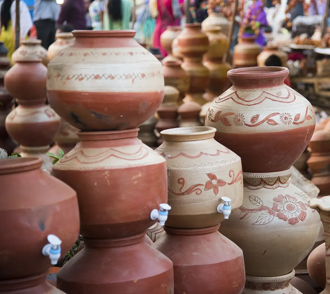 Earthen water purifier stacked up together in a rustic display. 