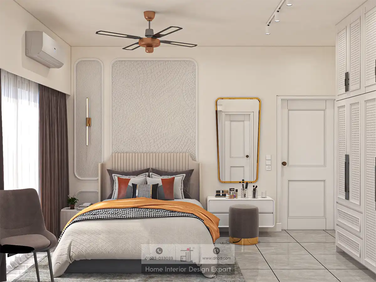 Modern bedroom with stylish decor: features a bed with orange and gray accents, wall art, a ceiling fan, a vanity with a mirror, and a cabinet.